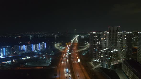 Modern Skyscrapers near the Bridge at the Night Aerial View City Traffic