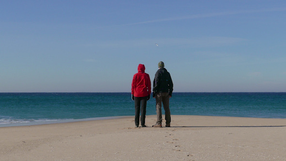 Happy Middle-aged Couple Walking on Beach