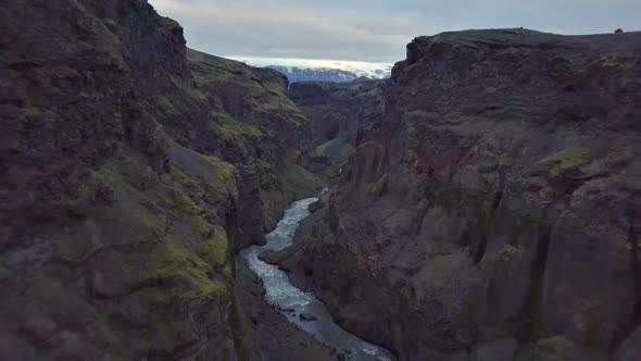 Fly Backwards in Dark River Canyon in Volcanic Iceland Nature