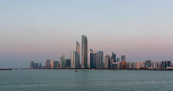 Abu Dhabi City Skyline with Skyscrapers Before Sunset with Water Reflection Day to Night Transition