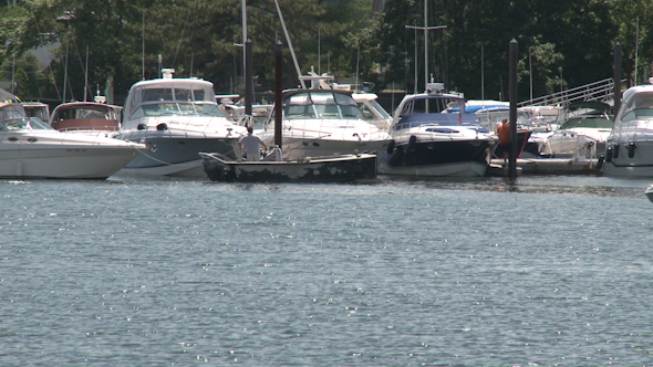 Boats Moving Slowly In Front Of Docked Boats.