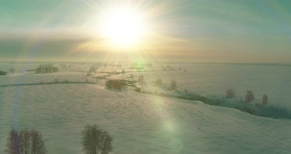 Aerial View of Cold Winter Landscape Arctic Field Trees Covered with Frost Snow Ice River and Sun