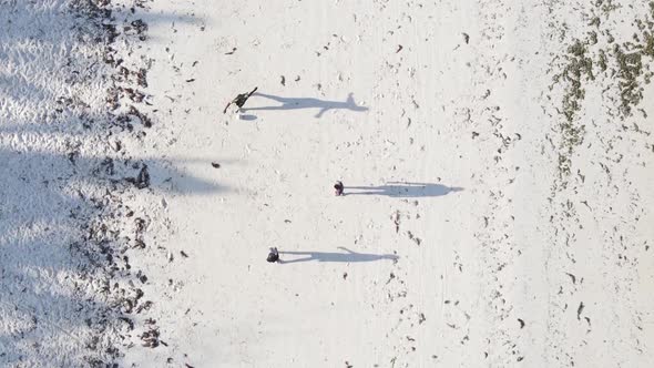 Vertical Video People Play Football on the Beach in Zanzibar Tanzania Aerial View