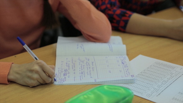 Female Students Writing on Copybook