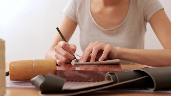 Woman making of leather wallet