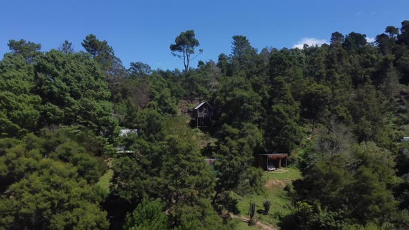 Drone shot of an eco farm in Hogsback, South Africa - drone is reversing from a self made guest room