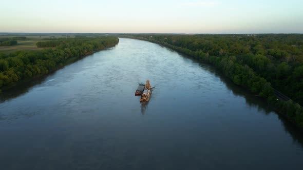 Aerial view overlooking a dredger cleaning the Missouri river, sunny evening in USA