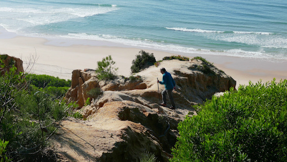 Man Climb on a Cliff Above the Ocean