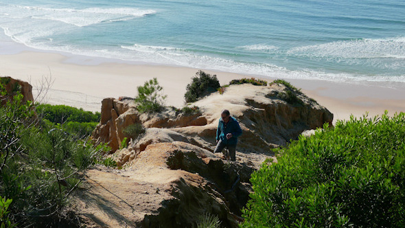 Man Climb on a Cliff Above the Ocean