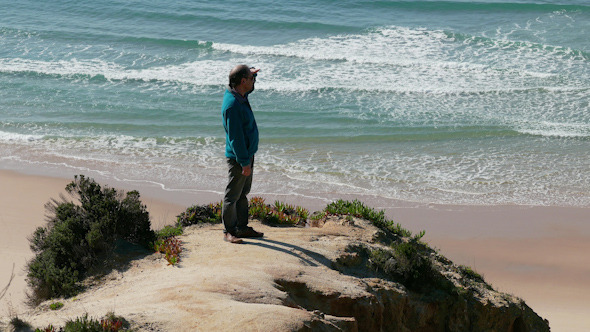 Man Climb on a Cliff Above the Ocean