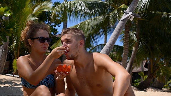 Couple Eating Fruits on the Beach