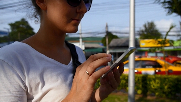Woman Typing on Phone and Walking