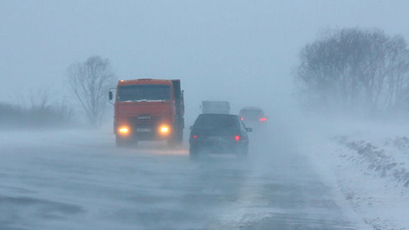 Cars On Winter Road At Blizzard