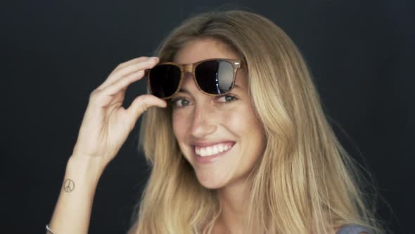 Woman putting on sunglasses and tossing hair