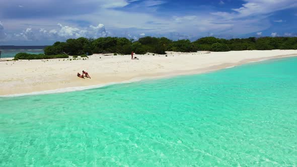 Girls tan on luxury seashore beach trip by shallow ocean with white sandy background of the Maldives