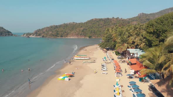 Aerial 4k drone footage of visitors at a tropical beach in Palolem, India.