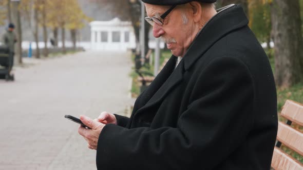 Excited elderly man winner holding using smartphone feeling overjoyed with mobile online bet bid gam