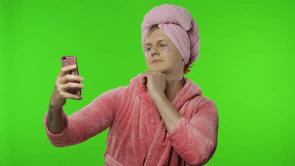 Portrait of Transsexual Man in Bathrobe Making Selfies Using Mobile Phone