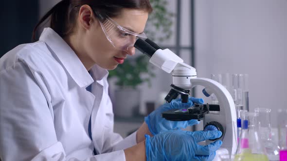 DNA Research in Modern Laboratory Woman is Viewing Sample Under Microscope