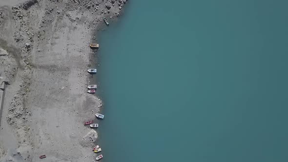 Aerial Birds Eye View Of Boats Moored At Attabad Lake Shore. Dolly Forward
