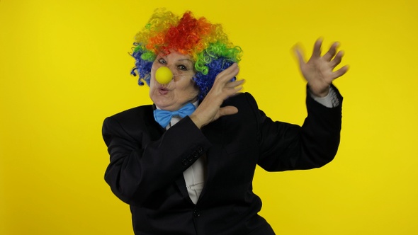 Senior Old Woman Clown in Wig Having Fun, Smiling, Dancing, Making Silly Faces