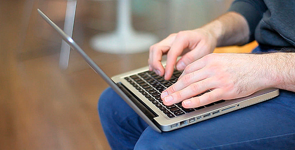 Man Sitting and Working on a Laptop