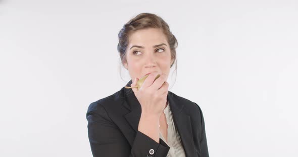 Woman eating a big pear on a white studio background