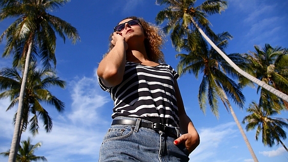 Woman Talking on Phone against Palm Trees