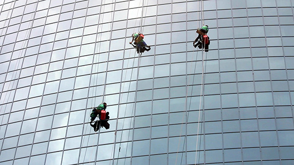 Window Cleaners At Work On Skyscraper