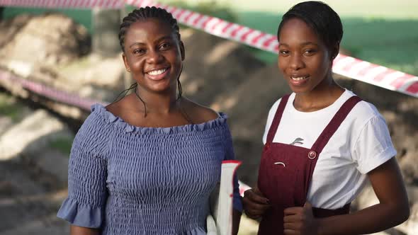 Two Confident Female African American Landscapers Looking at Camera Smiling in Slow Motion Standing