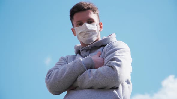 Guy in a medical mask and hood looking straight at the camera. COVID-19 or coronavirus 2019 concept