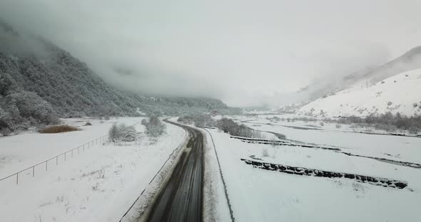 Beautiful aerial shot of the road and river in snowy nature