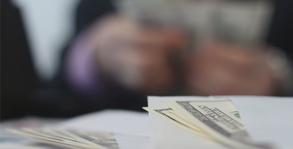 Businessman Counts Dollars in His Office alt