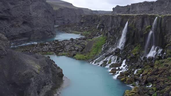 Turquoise river with waterfalls in highlands