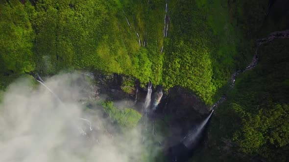 Aerial view above waterfall surrounding by jungle, Faroe Island.