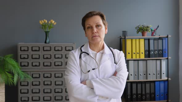 Happy Senior European Woman Doctor Wearing White Medical Coat and Stethoscope Looking at Camera