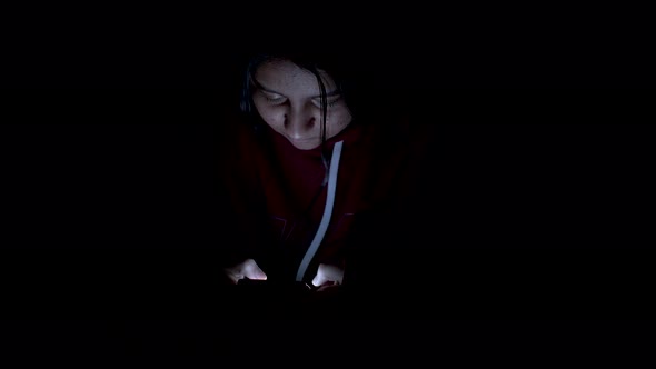Asian woman playing game on smartphone in the bed at night, people,Addict social media.