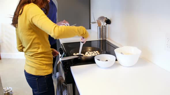 Woman preparing grapes tart in kitchen