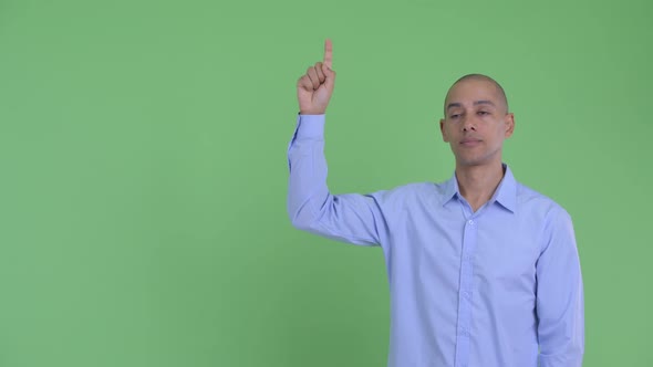 Stressed Bald Multi Ethnic Businessman Pointing Up