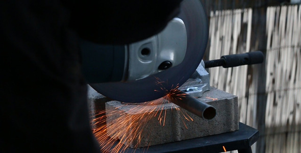 Worker With Angle Grinder Cutting Steel