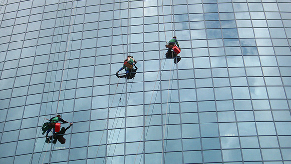 Window Cleaners At Work On Skyscraper