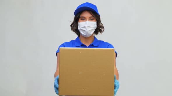 Delivery Woman in Face Mask Holding Parcel Box
