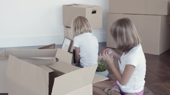 Adorable Girls Unpacking Things in New Apartment