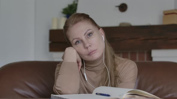 Blond Grey-eyed Woman in Headphones Listening To Someone in Online Chat