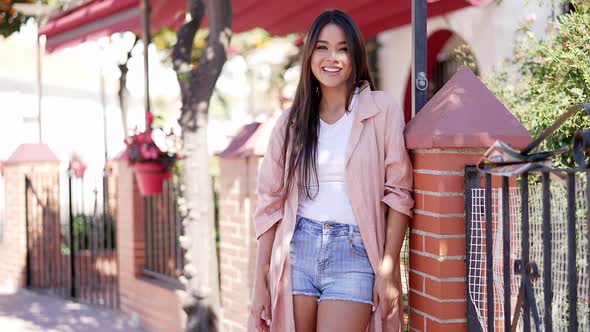 Smiling Stylish Brunette Leaning on Fence