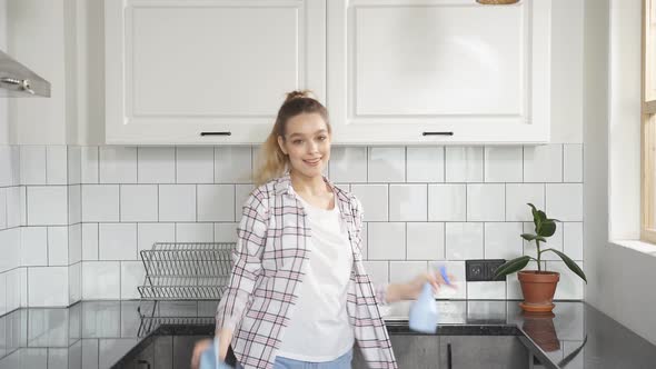 Attractive Young Caucasian Man Washing Dishes at Kitchen Sink While Doing Cleaning at Home at