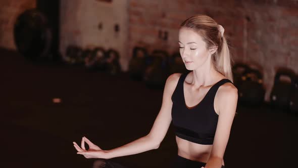 Fit Young Woman Meditating In Gym