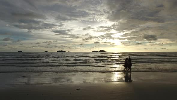 Aerial view of two womans walking on beach during sunset, Ko Chang, Thailand.