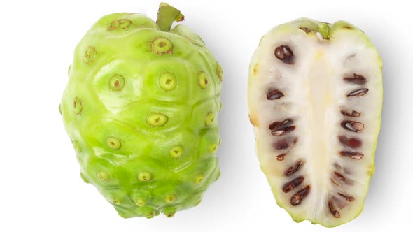 Panning Noni or Morinda Citrifolia fruits with sliced on white background