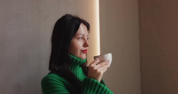 Woman Drinks Coffee Sitting in Cafe